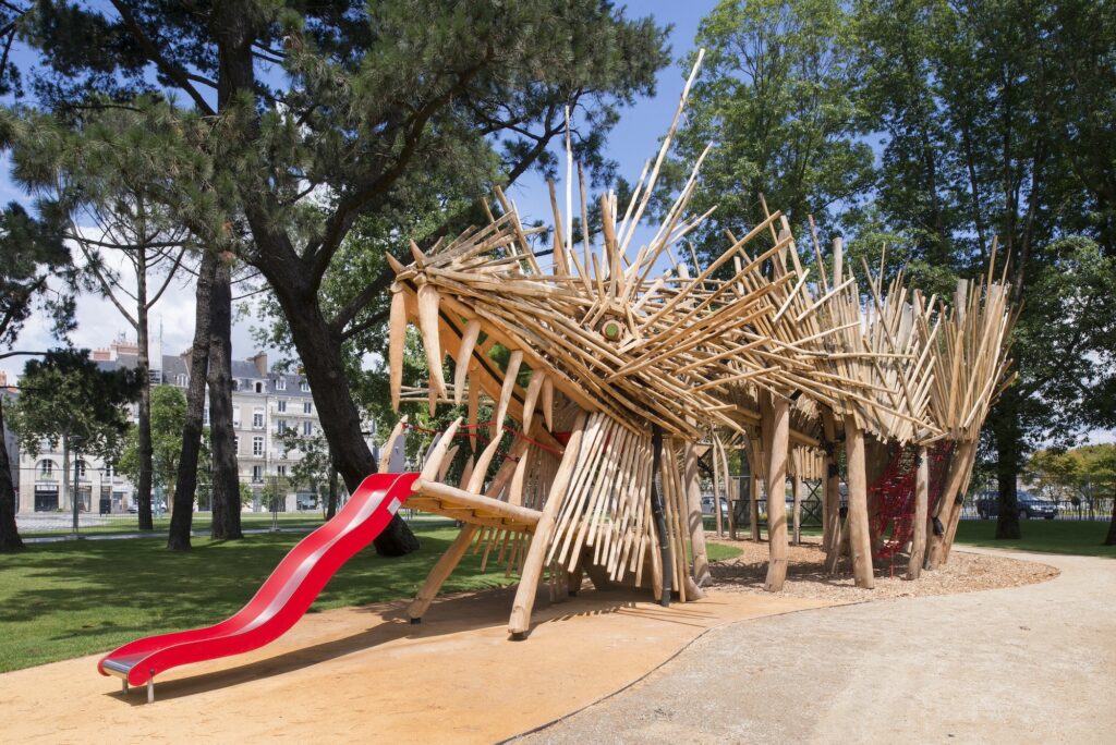 un toboggan est suspendu à un animal fantastique en bois